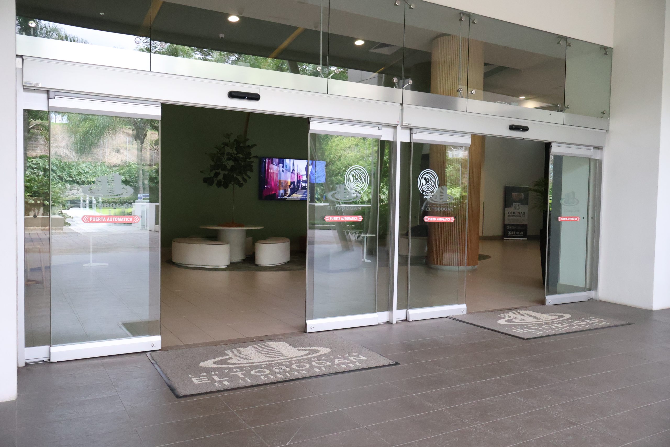 Puertas automáticas solo vidrio a la entrada del edifico corporativos El Tobogán