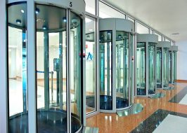 Cabinas de seguridad tipo mantrap de cristal y aluminio instaladas en el vestíbulo de un edificio corporativo para control de acceso estricto.